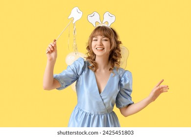 Tooth Fairy with wand on yellow background - Powered by Shutterstock