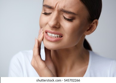 Tooth Pain And Dentistry. Beautiful Young Woman Suffering From Terrible Strong Teeth Pain, Touching Cheek With Hand. Female Feeling Painful Toothache. Dental Care And Health Concept. High Resolution