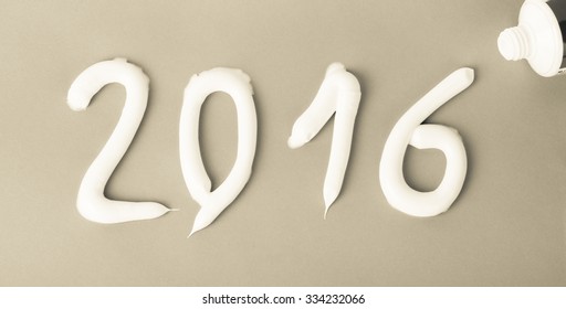 Tooth Paste In The Form Of Numbers 2016 On The Green Paper Background. Christmas Theme. Toned.