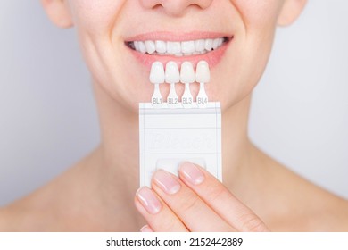 Tooth whitening, perfect white teeth close up with shade guide bleach color, female veneer smile, dental care and stomatology, dentistry - Shutterstock ID 2152442889