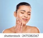 Toothache, pain and woman in studio with dental problem for cavity crisis and decay from bacteria. Female person, hand on face and jaw injury with surgery for teeth extraction by blue background