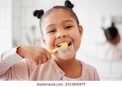 Toothbrush, brushing teeth and face of a child in a home bathroom for dental health and wellness. Smile portrait of african girl kid cleaning mouth with a brush for morning routine and oral self care - Shutterstock ID 2311850479