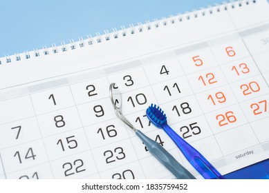The toothbrush and dental instrument are on the calendar. Dental health and teeth care concept