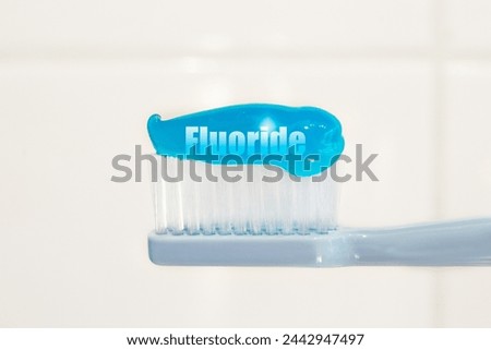  Toothbrush and fluoridated toothpaste on white background