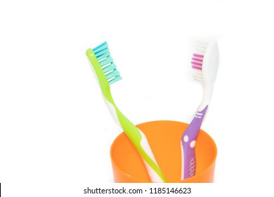 A toothbrush in a glass cup isolated on a white background. Care of teeth. Teeth cleaning. Beauty and health. Healthy teeth.