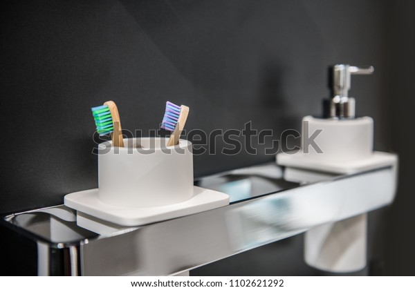 Toothbrush holder and liquid soap on holder on\
bathroom wall