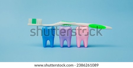 Toothbrush and mockups of three colorful teeth on a blue background. Teeth on a blue background. Dental health concept. Stomatology. Place for text. Oral health and dental inspection teeth. Dentistry.
