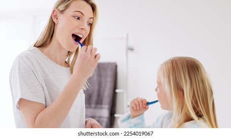 Toothbrush, mother and girl cleaning their teeth in the morning in the bathroom of their family home. Happy, bond and mom doing a dental hygiene routine for health with oral products with her child. - Powered by Shutterstock