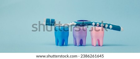 A toothbrush rests on mock-ups of three colorful teeth. Teeth on a blue background. Dental health concept. Stomatology. Place for text. Oral health and dental inspection teeth. Dentistry.