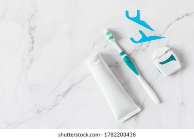 Toothbrush, toothpaste and dental floss top view on white marble background. Dental hygiene concept. - Powered by Shutterstock