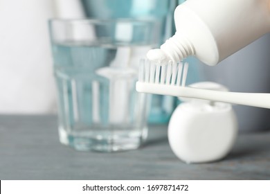 Toothbrush with toothpaste on background with dental care tools, close up