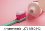 Toothbrush with toothpaste on a pink background