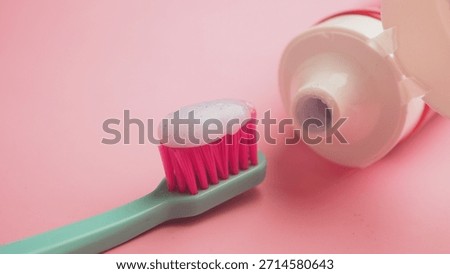 Toothbrush with toothpaste on a pink background