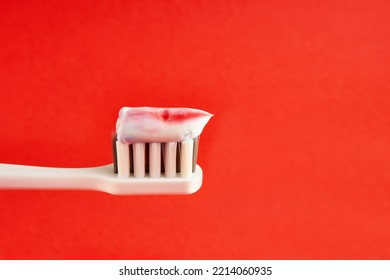Toothbrush with toothpaste on a red background. Dental care. Oral hygiene.