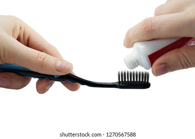 A Toothbrush And Tube Of Toothpaste In A Hand Isolated On White Background, Squeezing Toothpaste On The Toothbrush