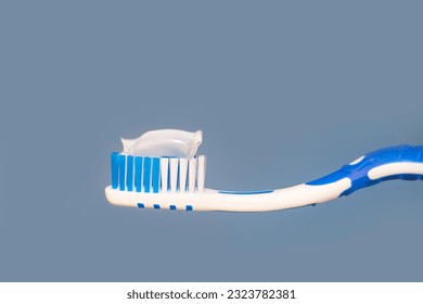 Toothbrush with white toothpaste close up on blue background. - Powered by Shutterstock