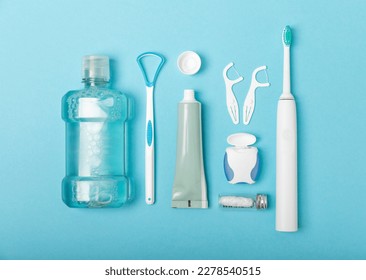Toothbrush,electric toothbrush,tongue cleaner, floss, toothpaste tube and mouthwash on blue background with copy space. Flat lay. Dental hygiene. Oral care kit. Dentist concept.Dental care. - Shutterstock ID 2278540515