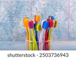 Toothbrushes in ceramic bowl on blurred background.  Morning hygiene. Bathroom accessories images. Toothbrush on a blue background. Colorful toothbrushes, healthy tooth concept.