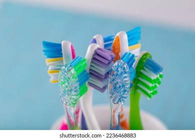 Toothbrushes in ceramic bowl on blurred background. Colorful toothbrushes, healthy tooth concept.