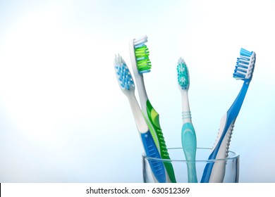 Zahnbürsten auf Glas auf buntem Hintergrund