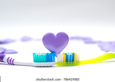 Toothbrushes on white background with purple hearts Valentine's day