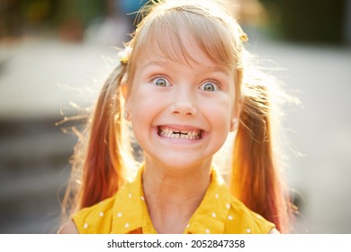 Toothless childish smile. Little cute girl child laughs, shows the fallen out first milk tooth. Children's dentistry. Funny face
