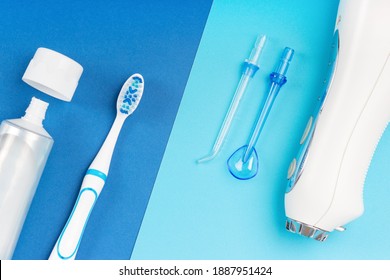 Toothpaste, toothbrush and dental irrigator on a blue background close-up. - Shutterstock ID 1887951424