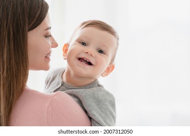 Toothy smile of a little small kid child, embracing his mother nanny babysitter. Happy moments of motherhood. Adoption vitro IVF concept