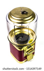 Top 3/4 View Of A Retro Vintage Coin Operated Red & Gold Candy And Gumball Dispensing Vending Machine With Round Yellow & Black 25 Cents Quarter Sticker On Plastic Glass Dome & Tubular Lock Key In Top