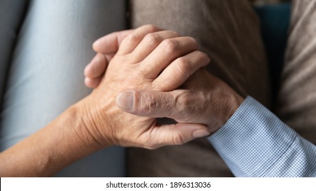 Top Above Close Up View Loving Affectionate Old Senior Married Family Couple Holding Hands, Enjoying Sweet Tender Moment Together At Home, Showing Support And Care To Each Other, Relations Concept.