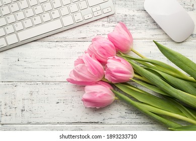 Top above close up view photo of bouquet of tender pastel tulips computer keyboard and mouse on white wooden desk