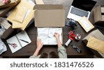 Top above closeup view of female online store small business owner entrepreneur packing package post shipping box preparing delivery parcel on table. Ecommerce dropshipping shipment service concept.