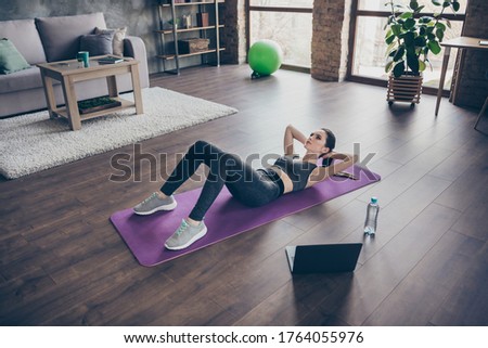 Top above high angle full body view photo of athlete active sportive girl watch online video laptop yoga pilates workout doing crunches on mat floor wear panties in house indoors