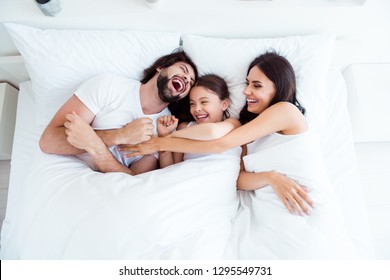 Top above high angle view of nice cute lovely attractive cheerful cheery glad people lying in bed enjoying cuddling daddy day free time in white light interior room indoors