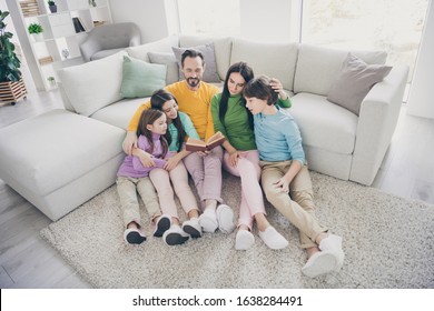 Top Above High Angle View Photo Of Positive Cheerful Fun Family Sit Floor Carpet Near Sofa Couch Dad Read Book Mom Three Preteen Little Adopted Kids Listen Story Enjoy Novel In Room House