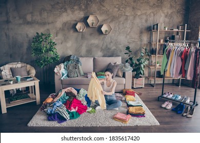 Top above high angle view photo of focused girl sit carpet legs crossed folded, arrange tidy dressing pile stack order in house indoors