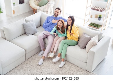 Top Above High Angle View Full Body Photo Of Family Happy Positive Smile Sit Sofa Indoors Laugh Watch Comedy Remote Controller