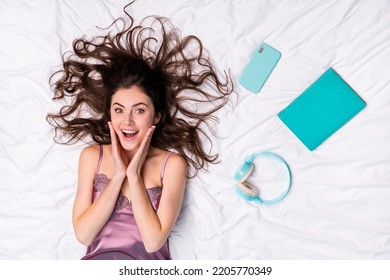 Top above high angle view portrait of attractive wondered cheerful girl using device good mood lying on bed linen home - Shutterstock ID 2205770349