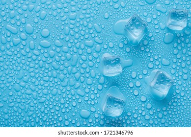 Top above overhead close up macro view photo of ice cubes and water drops on blue background with copy empty blank space