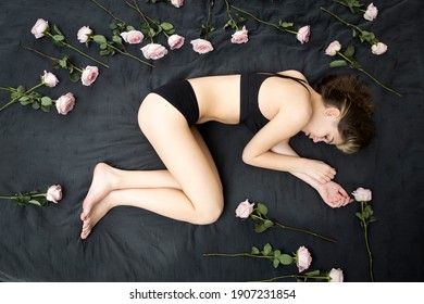 Top Above View Stressed Middle Aged Woman Lying On Bed In Fetal Position, Embracing Knees, Suffering From Depression Or Insomnia. Upset Mature Lady Feeling Unwell, Having Health Problems. Amongst Rose