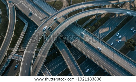 Top up aerial drone view of elevated road and traffic junctions in Chinese metropolis city Chengdu during sunny day. Modern construction design of traffic ways to avoid traffic jams. Few vehicles.
