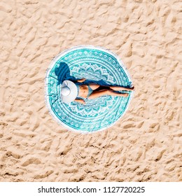Top Aerial Drone View Of Woman In Swimsuit Bikini Relaxing And Sunbathing On Round Turquoise Beach Towel Near The Ocean