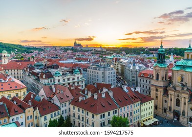 Top aerial panoramic view of Prague Old Town historical city centre with red tiled roof buildings and Prague Castle, St. Vitus Cathedral in Hradcany district in evening sunset, Bohemia, Czech Republic