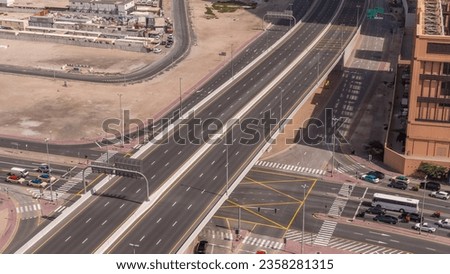 Top aerial view of busy road intersection and traffic junctions in Dubai city timelapse. Modern construction design of crossroads and highways to avoid traffic jams. Many driving cars