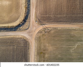 Top Aerial View Of Crossroad And Furrows Row Pattern In A Plowed Field Prepared For Planting Crops In Spring. Growing Wheat Crop In Springtime. Aerial View Of Harvest Fields In Lithuania