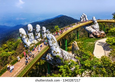 Top aerial view of the famous Golden Bridge is lifted by two giant hands in the tourist resort on Ba Na Hill in Da Nang, Vietnam. " Cau Vang" is a favorite destination for tourists

