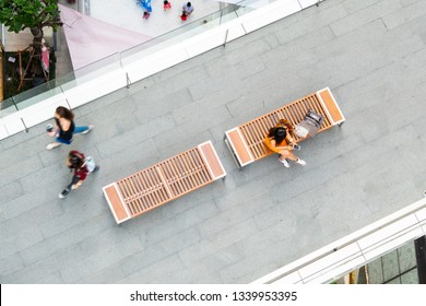 Top Aerial View Fashion Woman With Shopping Bag Uses Smartphone Sit On Wooden Bench At Walkway Pedestrian With Blur People Are Walking, , Concept Of Social Still Life With Technology And Lifestyle