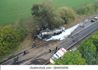 Top Aerial View. The Fuel Truck Crashed Into A Tree And Caught Fire. Fire Truck And Ambulance Came To The Rescue