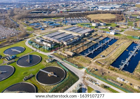 Top aerial view of purification tanks of modern wastewater treatment plant, the waste water and sewage treatment plant is located in the town of Leeds in West Yorkshire UK, taken in the winter time.