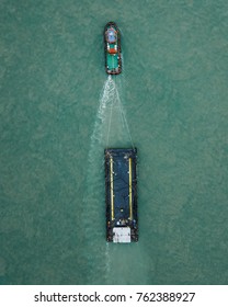 Top Aerial View Of A Tug Boat Towing An Empty Barge Taken On A Drone